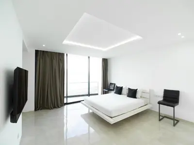 a white bedroom with a bed and a television at Apartment Sunset in Mindelo
