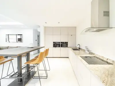 a white kitchen with white cabinets and a large island at Apartment Sunset in Mindelo