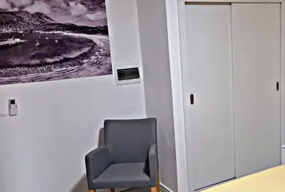 a chair in a room with a picture on the wall at Apartamentos Santiago - Tarrafal in Tarrafal