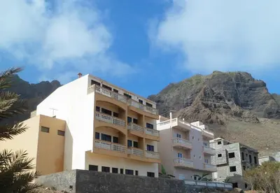 a large building with a mountain in the background at Kolina D´Sol in Ponta do Sol