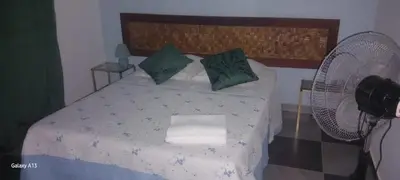 a bedroom with a bed with a fan at Kolina D´Sol in Ponta do Sol